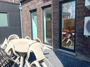 a wooden table and chairs in front of a window at L'entracte in Hensies