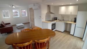 a kitchen with a wooden table and a dining room at L'entracte in Hensies