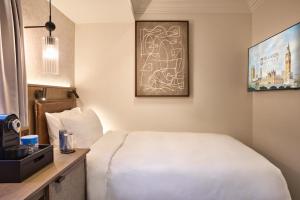 a hotel room with a white bed and a tv at Radisson Blu Hotel, London Euston Square in London +69 photos