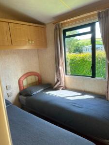 a small bedroom with two beds and a window at 31 Mobile Home Lemon Park Devon in Bickington