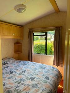 a bedroom with a bed in front of a window at 31 Mobile Home Lemon Park Devon in Bickington