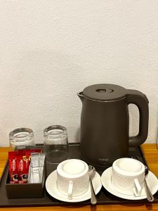 a black coffee maker sitting on a tray with plates at Tranquil Retreat Dhigurah in Dhigurah