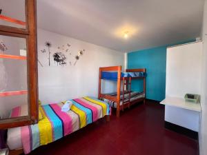 a childs bedroom with a bunk bed and a shelf at Wayra Hostel Huanchaco in Huanchaco