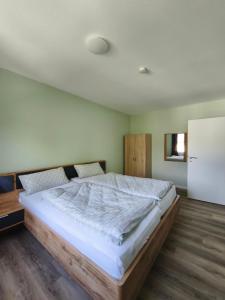 a bedroom with a large bed and a refrigerator at Fewo Gloria in Altenbeken