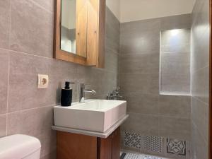 ein Badezimmer mit weißem Waschbecken und Dusche in der Unterkunft Mastic Nest in Chios