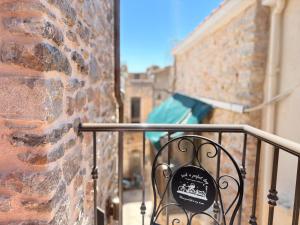ein Schild an einem Geländer neben einer Backsteinmauer in der Unterkunft Mastic Nest in Chios