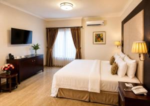 a hotel room with a bed and a desk at Chelsea Hotel Abuja in Abuja