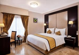 a hotel room with a large bed and a desk at Chelsea Hotel Abuja in Abuja