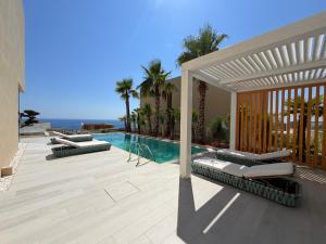 a swimming pool with chaise lounges next to a house at Villa Azul in Palasë