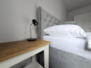 a bedroom with a bed and a desk with a lamp at Apartman H4 in Žilina