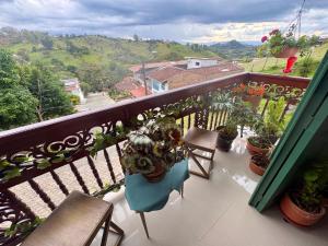 a balcony with chairs and potted plants on it at Blomst Casa Hostal in Jericó