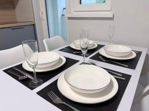 a dining room table with plates and glasses on it at Apartman H4 in Žilina