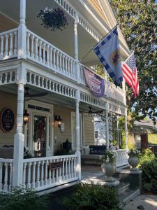 a white house with two flags on the porch at Ann Street Inn & Garden in Beaufort