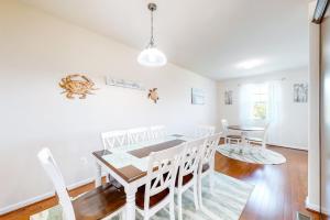 a white dining room with a table and chairs at Seaside Village --- #3 in Ocean City