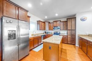 a kitchen with wooden cabinets and a stainless steel refrigerator at Seaside Village --- #3 in Ocean City +25 photos
