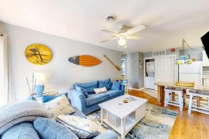 a living room with a blue couch and a table at Whispering Woods #26 in Ocean City