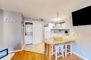a kitchen with a table and a tv in a room at Whispering Woods #26 in Ocean City