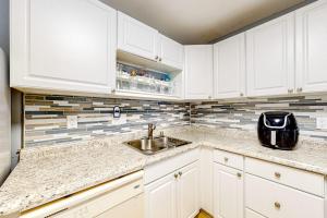 a kitchen with white cabinets and a sink at Whispering Woods #26 in Ocean City