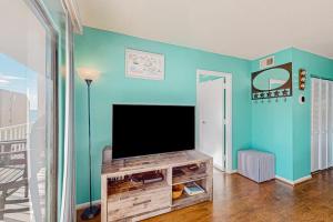 a living room with a flat screen tv on a blue wall at Wight Bay North #439 in Ocean City