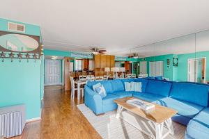 a living room with a blue couch and a table at Wight Bay North #439 in Ocean City