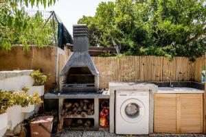 a garden with a washing machine and a fence at PortoPollo SurfHouse C in Barrabisa