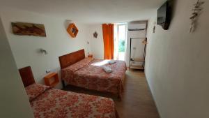 a small room with two beds and a window at PortoPollo SurfHouse C in Barrabisa