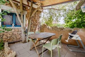 a wooden table and chairs on a patio at PortoPollo SurfHouse C in Barrabisa