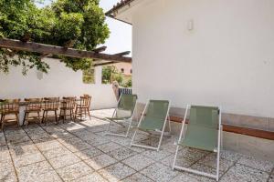 a group of chairs and a table and a table and chairsearcher at PortoPollo SurfHouse C in Barrabisa