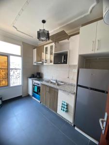 a kitchen with a refrigerator and a sink in it at Résidence les Palaja in Douala