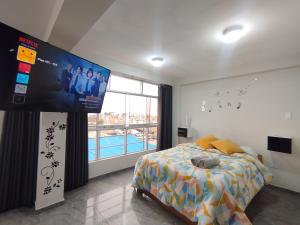 a bedroom with a bed and a large screen at Apartamentos "APPART D'ELIETTE" in Trujillo