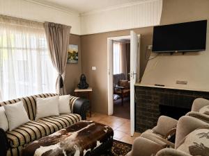 a living room with two couches and a fireplace at Nawi Unit 3 in Potchefstroom