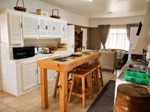 a kitchen with a wooden table and a counter top at Nawi Unit 3 in Potchefstroom