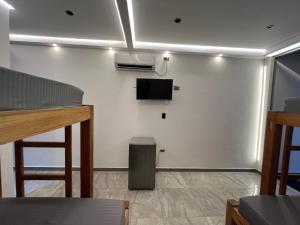 a room with a tv on a white wall at Hotel Magic Capurganá in Capurganá