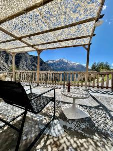 a chair and a table on a patio with mountains at le Belvédère Maison d hotes in Sainte-Anne