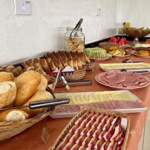 a table with many different types of bread and pastries at Pousada Werneck Residence Suites in Ubatuba