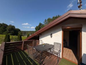 a patio with a table and chairs on a deck at Apartament ADA in Niesulice
