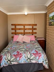 a bedroom with a large bed with pink pillows at Nawi Unit 3 in Potchefstroom