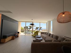 a living room with a couch and a flat screen tv at Villa Azul in Palasë