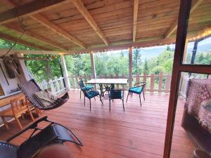 a porch with a hammock and a table and chairs at Ostaya - Mountain Cottage in Obidza +18 photos