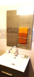 a bathroom with a sink and a mirror and towels at Le coin tranquille in Saint-Denis