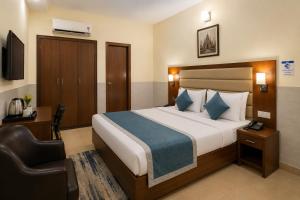 a hotel room with a bed and a chair at Subhan Palace Guest House in Karachi