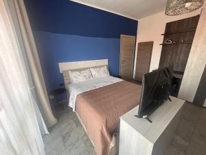 a small bedroom with a bed and a tv at Dante appartamento in Fagnano Olona