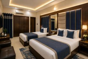 a hotel room with two beds and a television at Subhan Palace Guest House in Karachi +19 photos