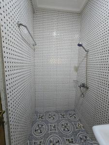 a white tiled bathroom with a shower and a sink at 2 bedroom super cozy apartment in Accra +6 photos
