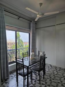 a dining room with a table and chairs and a window at 2 bedroom super cozy apartment in Accra