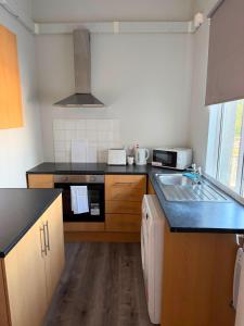 a kitchen with a sink and a stove top oven at Stylish Bolton Stay Parking Walk to Town Centre in Farnworth