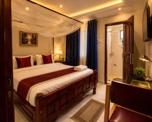a bedroom with a large bed with a canopy at Coco Hotel Busia in Busia