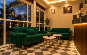 a living room with two green couches and a table at Coco Hotel Busia in Busia