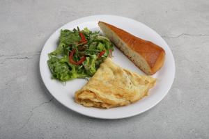a plate of food with a omelet and a sandwich and salad at Camping Sandalandia in Vama Veche