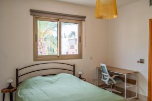 a bedroom with a bed and a desk and a window at Leda Beach Villa in Polis Chrysochous +52 photos